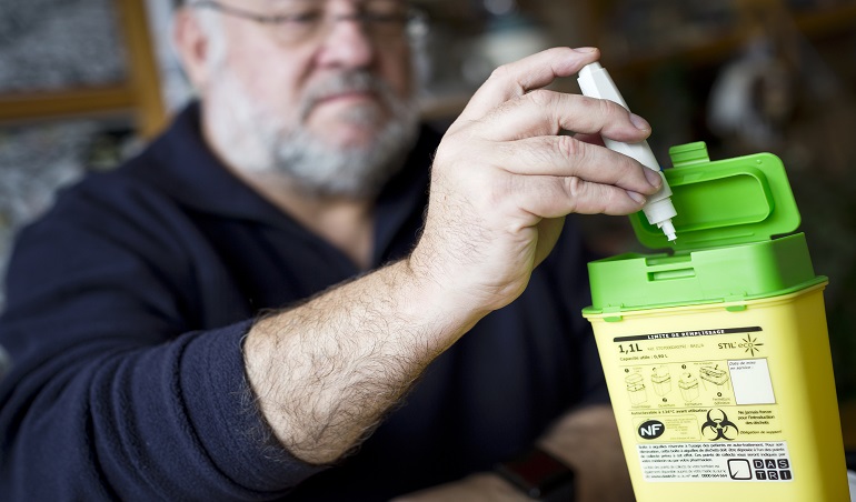 patients manipulant une boîte de déchets à aiguilles à son domicile